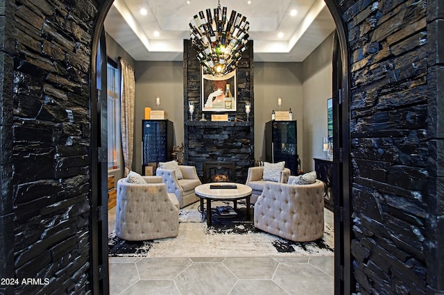 living area with a fireplace and a tray ceiling