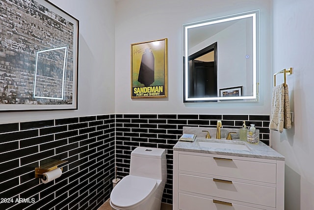 bathroom featuring vanity, toilet, and tile walls