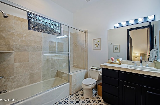 full bathroom featuring shower / bath combination with glass door, tile patterned floors, vanity, and toilet