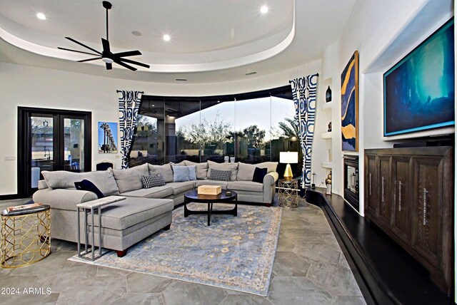 living room featuring ceiling fan and a raised ceiling