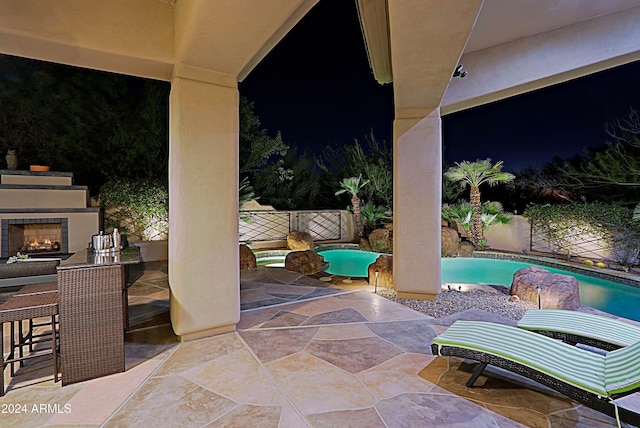 view of patio with a fenced in pool and exterior fireplace