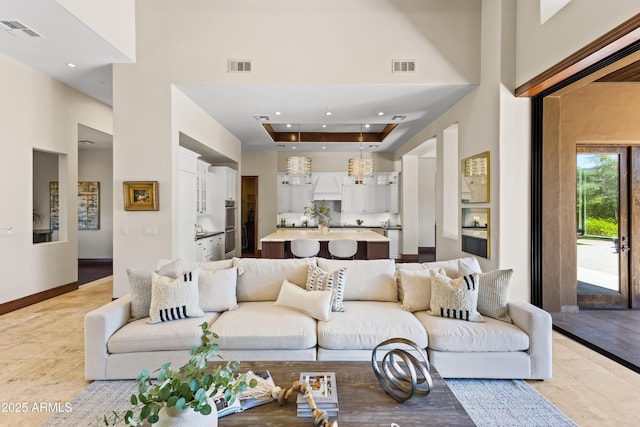 37334 N Winding Wash Trl, Carefree, AZ 85377 - living area with a tray ceiling, visible vents, baseboards, and a towering ceiling