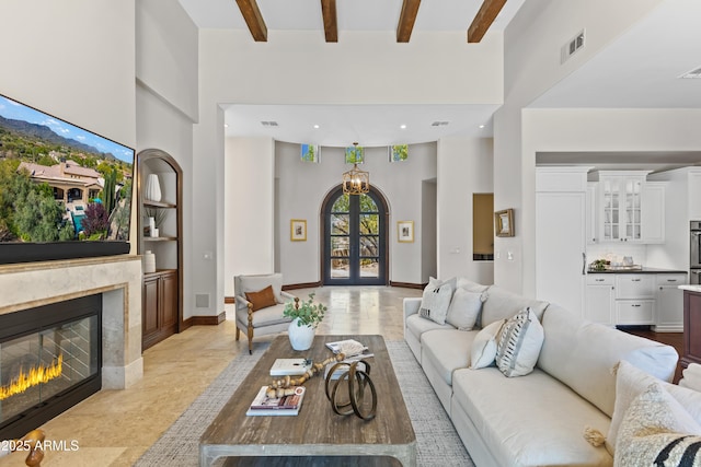 37334 N Winding Wash Trl, Carefree, AZ 85377 - living room with french doors, a high ceiling, a fireplace, and beamed ceiling