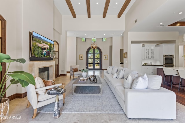 37334 N Winding Wash Trl, Carefree, AZ 85377 - living room featuring a glass covered fireplace, a towering ceiling, beamed ceiling, and visible vents