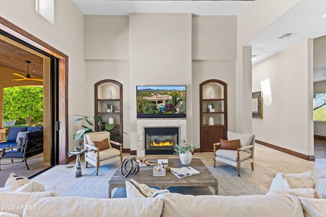 37334 N Winding Wash Trl, Carefree, AZ 85377 - living area with a glass covered fireplace, a towering ceiling, built in shelves, and visible vents