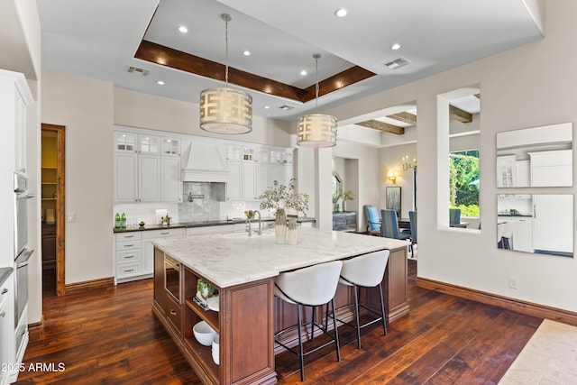 37334 N Winding Wash Trl, Carefree, AZ 85377 - kitchen featuring backsplash, a large island, visible vents, dark wood finished floors, and light stone counters