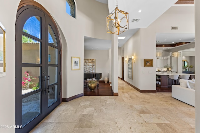 37334 N Winding Wash Trl, Carefree, AZ 85377 - entryway featuring baseboards, stone tile floors, a high ceiling, and a chandelier