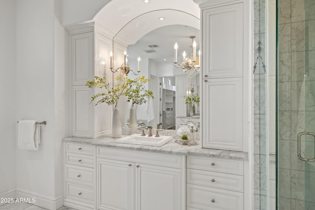 37334 N Winding Wash Trl, Carefree, AZ 85377 - full bathroom with visible vents, a stall shower, vanity, baseboards, and an inviting chandelier