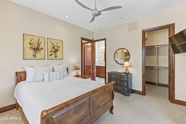 37334 N Winding Wash Trl, Carefree, AZ 85377 - bedroom with light colored carpet, a walk in closet, baseboards, visible vents, and a closet