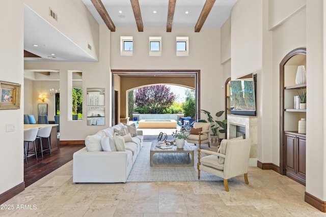 37334 N Winding Wash Trl, Carefree, AZ 85377 - living area with visible vents, a towering ceiling, beamed ceiling, baseboards, and built in shelves