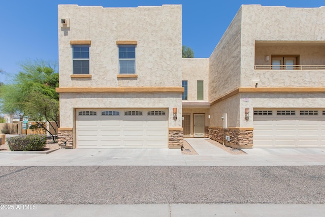 view of front facade with a garage, stucco siding, and stone siding