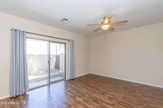 empty room featuring visible vents, a ceiling fan, dark wood-style flooring, and baseboards