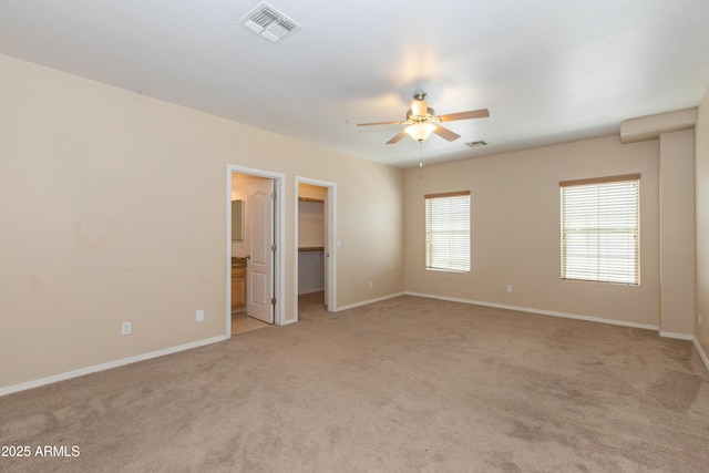 unfurnished room with visible vents, a ceiling fan, baseboards, and light carpet