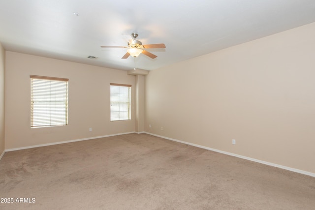 unfurnished room featuring baseboards, ceiling fan, light colored carpet, and visible vents
