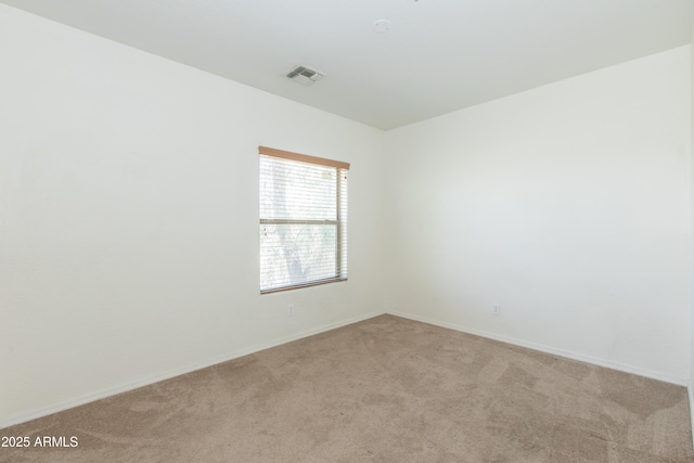 empty room with baseboards, light carpet, and visible vents