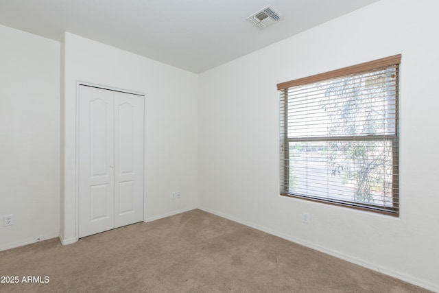 unfurnished room with baseboards, visible vents, a wealth of natural light, and carpet