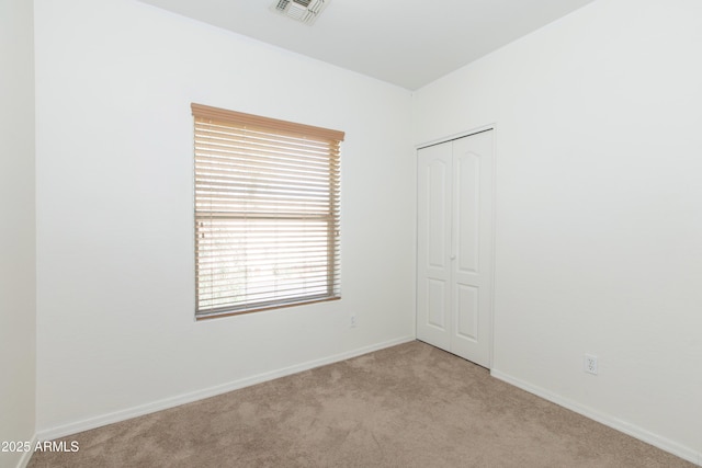 carpeted empty room with visible vents and baseboards