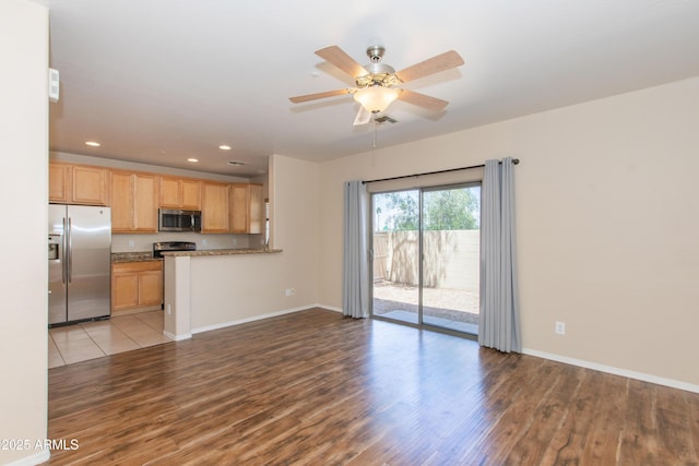 unfurnished living room with baseboards, a ceiling fan, wood finished floors, and recessed lighting