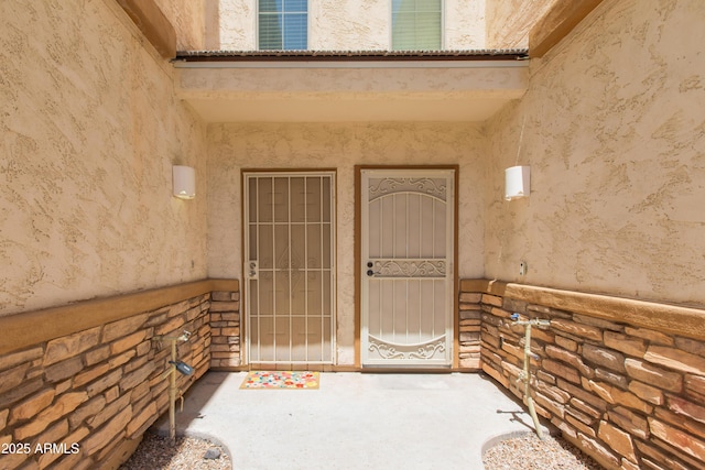 property entrance with stone siding and stucco siding