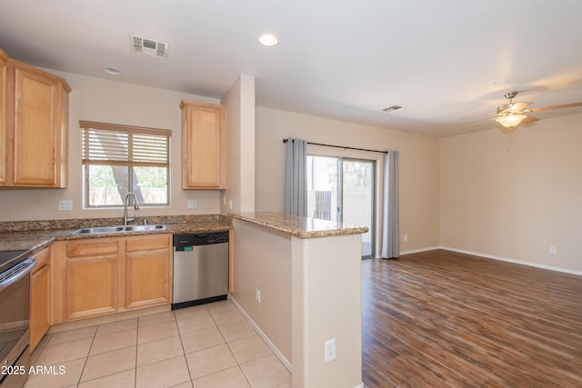 kitchen featuring plenty of natural light, visible vents, appliances with stainless steel finishes, a sink, and a peninsula