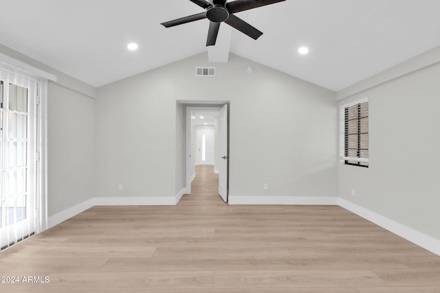 unfurnished room featuring light wood-type flooring, lofted ceiling with beams, and a wealth of natural light