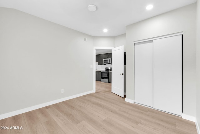 unfurnished bedroom featuring light wood-type flooring and a closet