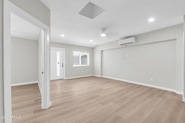 empty room with a wall mounted air conditioner and light wood-type flooring