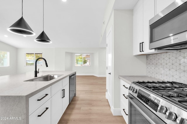 kitchen featuring appliances with stainless steel finishes, plenty of natural light, hanging light fixtures, and sink