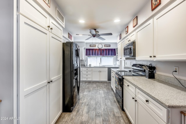 kitchen with sink, white cabinetry, black appliances, hardwood / wood-style floors, and ceiling fan