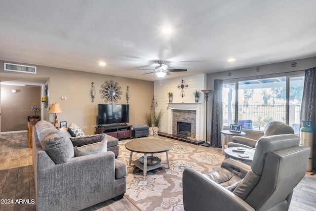 living room featuring a fireplace, hardwood / wood-style floors, and ceiling fan