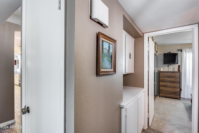 hall featuring washer / clothes dryer and light colored carpet