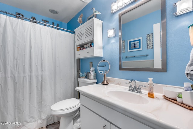 bathroom featuring walk in shower, vanity, and toilet