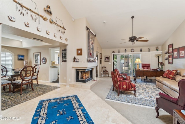 living room featuring a tile fireplace, light tile patterned floors, and high vaulted ceiling