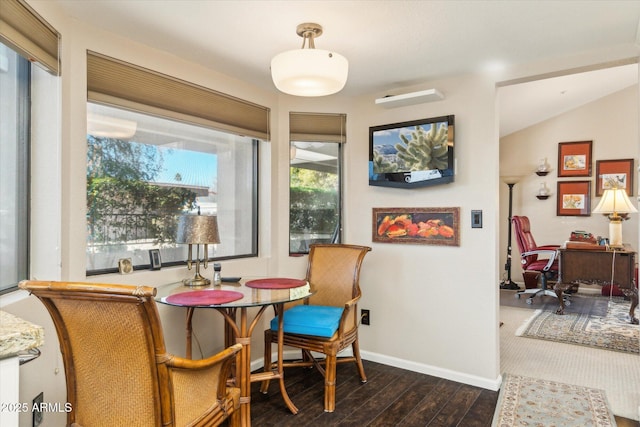 dining area featuring vaulted ceiling and dark wood-type flooring