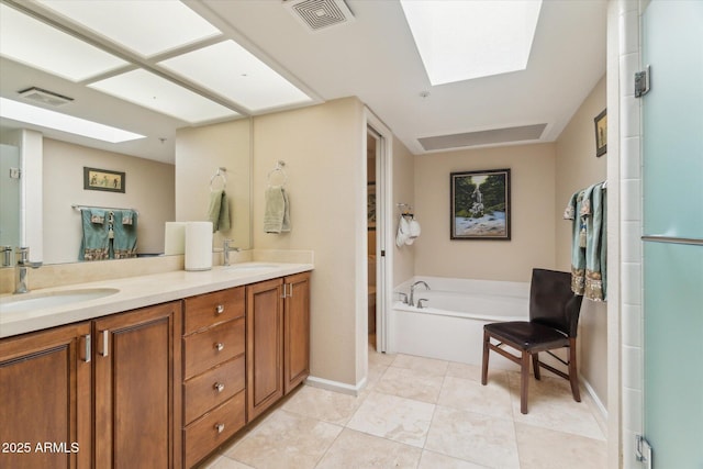 bathroom featuring vanity, a skylight, tile patterned flooring, and a bathtub