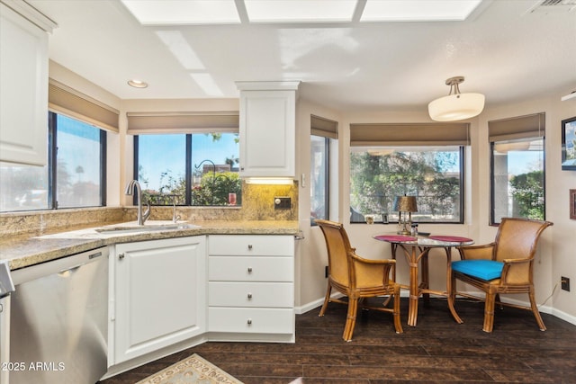 kitchen with dark wood-type flooring, stainless steel dishwasher, sink, and white cabinets