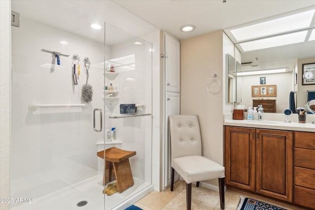 bathroom featuring a shower with door, vanity, and tile patterned flooring