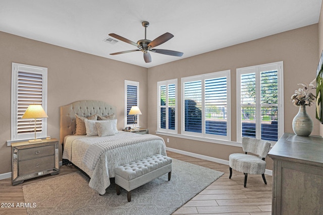 bedroom featuring multiple windows, ceiling fan, and light hardwood / wood-style floors