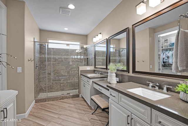 bathroom with vanity, a shower with shower door, and hardwood / wood-style flooring