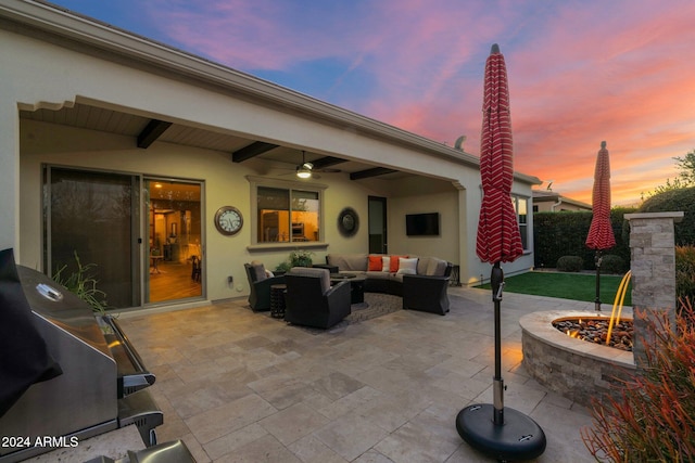 view of patio featuring ceiling fan and an outdoor living space with a fire pit