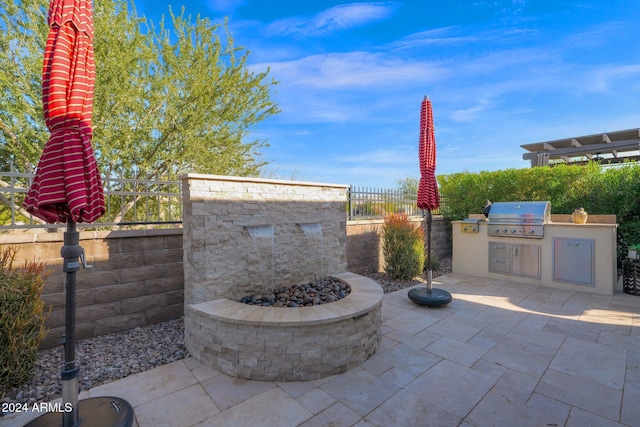 view of patio with a fire pit, area for grilling, and exterior kitchen