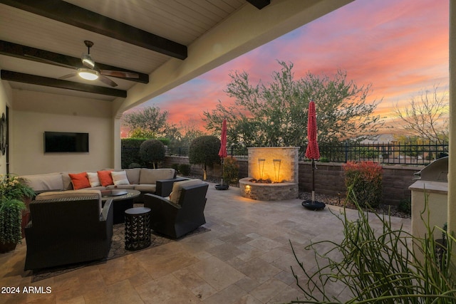 patio terrace at dusk with ceiling fan and an outdoor living space with a fire pit