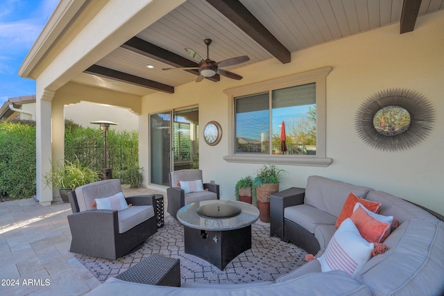 view of patio featuring ceiling fan and an outdoor living space with a fire pit