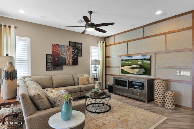 living room with ceiling fan, plenty of natural light, and light hardwood / wood-style floors