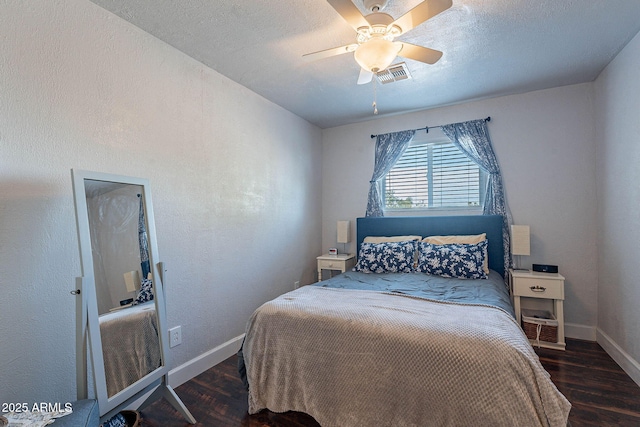 bedroom featuring dark hardwood / wood-style floors, a textured ceiling, and ceiling fan