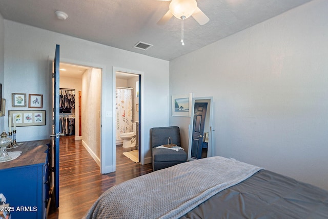 bedroom with ensuite bathroom, dark hardwood / wood-style floors, and ceiling fan