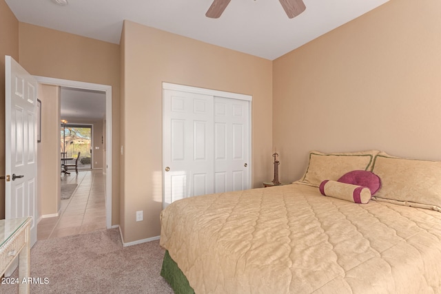 bedroom featuring a closet, light carpet, and ceiling fan