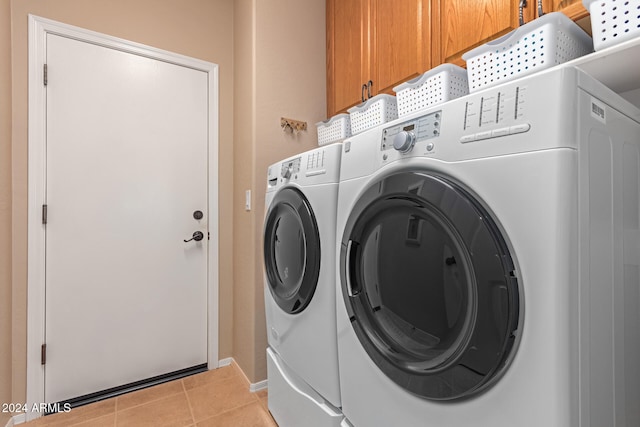 laundry area with separate washer and dryer, cabinets, and light tile patterned floors