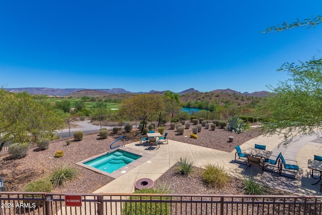 view of pool featuring a mountain view, an in ground hot tub, and a patio area