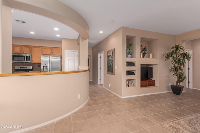 kitchen featuring light tile patterned flooring, appliances with stainless steel finishes, and tasteful backsplash